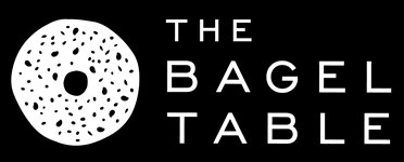 The Bagel Table logo white bagel black background