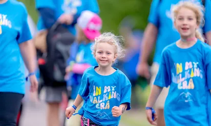 A group of kids wearing matching blue shirts that read "In my walking era" at the Eversource Walk for Kids