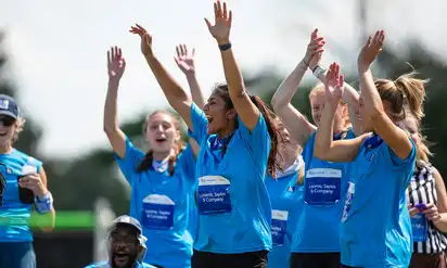 A group of Corporate Cup event participants shouting happily with their hands in the air