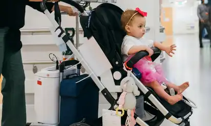 A BCH patient, Avianna, in a stroller hooked up to a complex piece of medical equipment