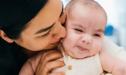 A mother kisses her baby son, Joshua