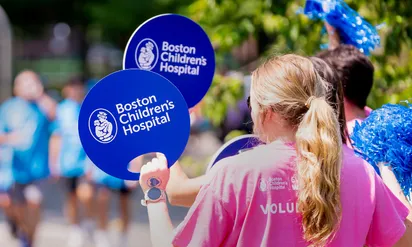People wave signs at event for Boston Childrens Hospital