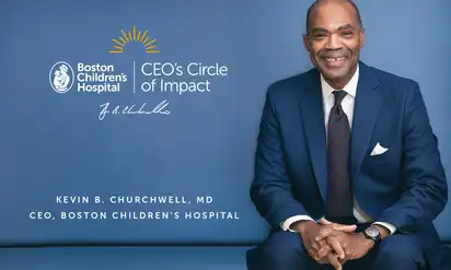 The CEO of Boston Children's Hospital smiles at the camera, with the Circle of Impact logo visible to his left