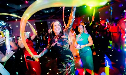 women smiling holding stretchy balloons at a gala