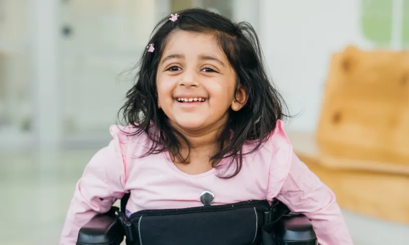 image of a toddler on a wheelchair smiling 