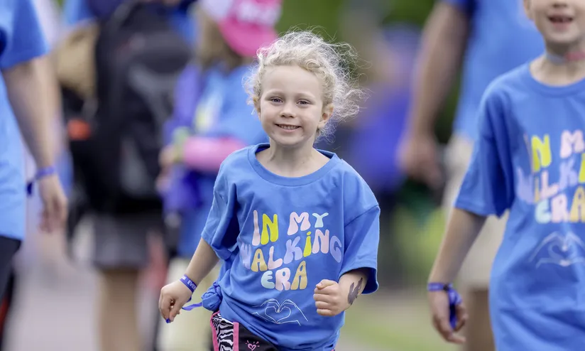 Group of kids wearing "in my walking era" blue t-shirts
