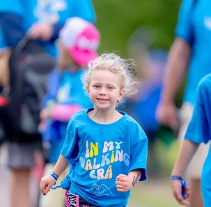 A group of kids wearing matching blue shirts that read "In my walking era" at the Eversource Walk for Kids