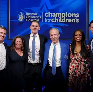 Champions for Childrens event speakers and guests pose in front of an event banner