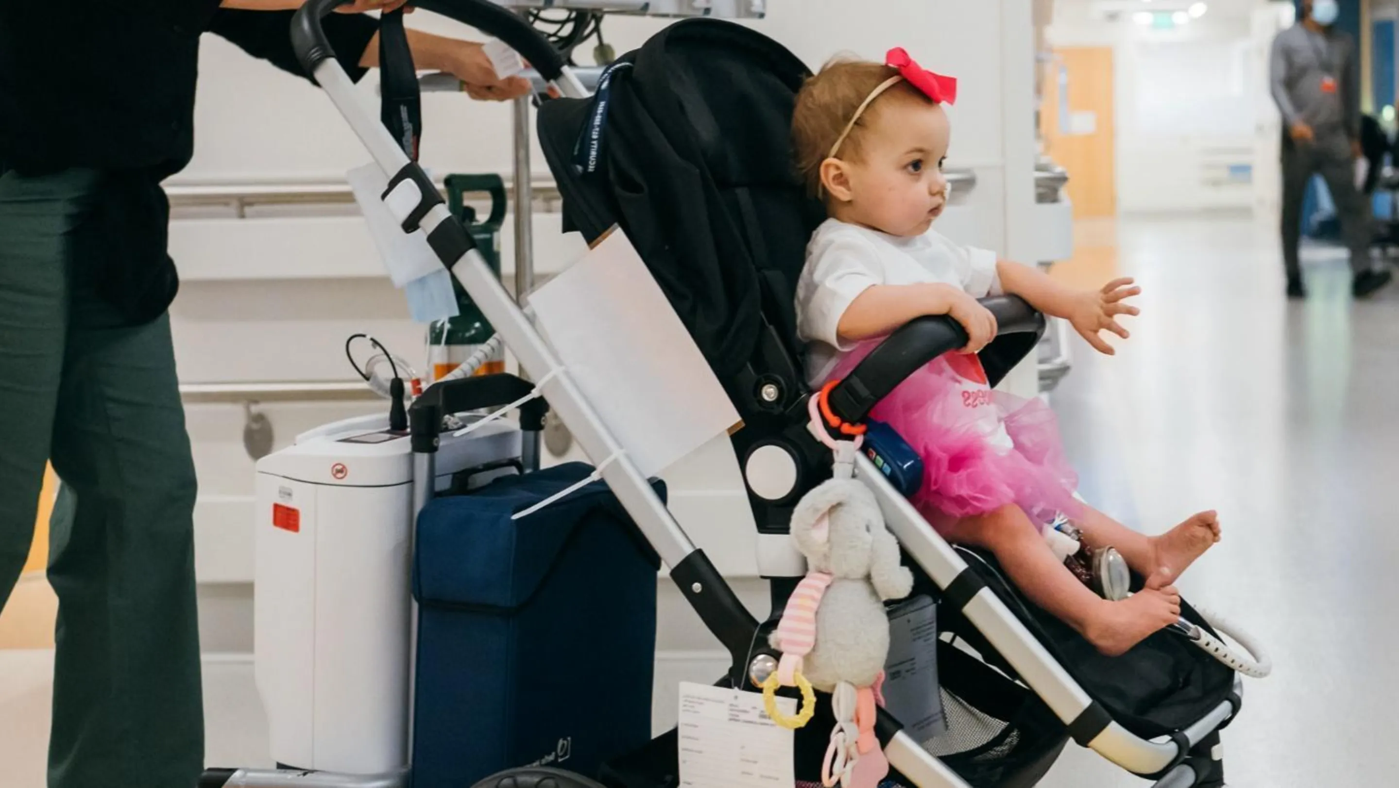 A BCH patient, Avianna, in a stroller hooked up to a complex piece of medical equipment