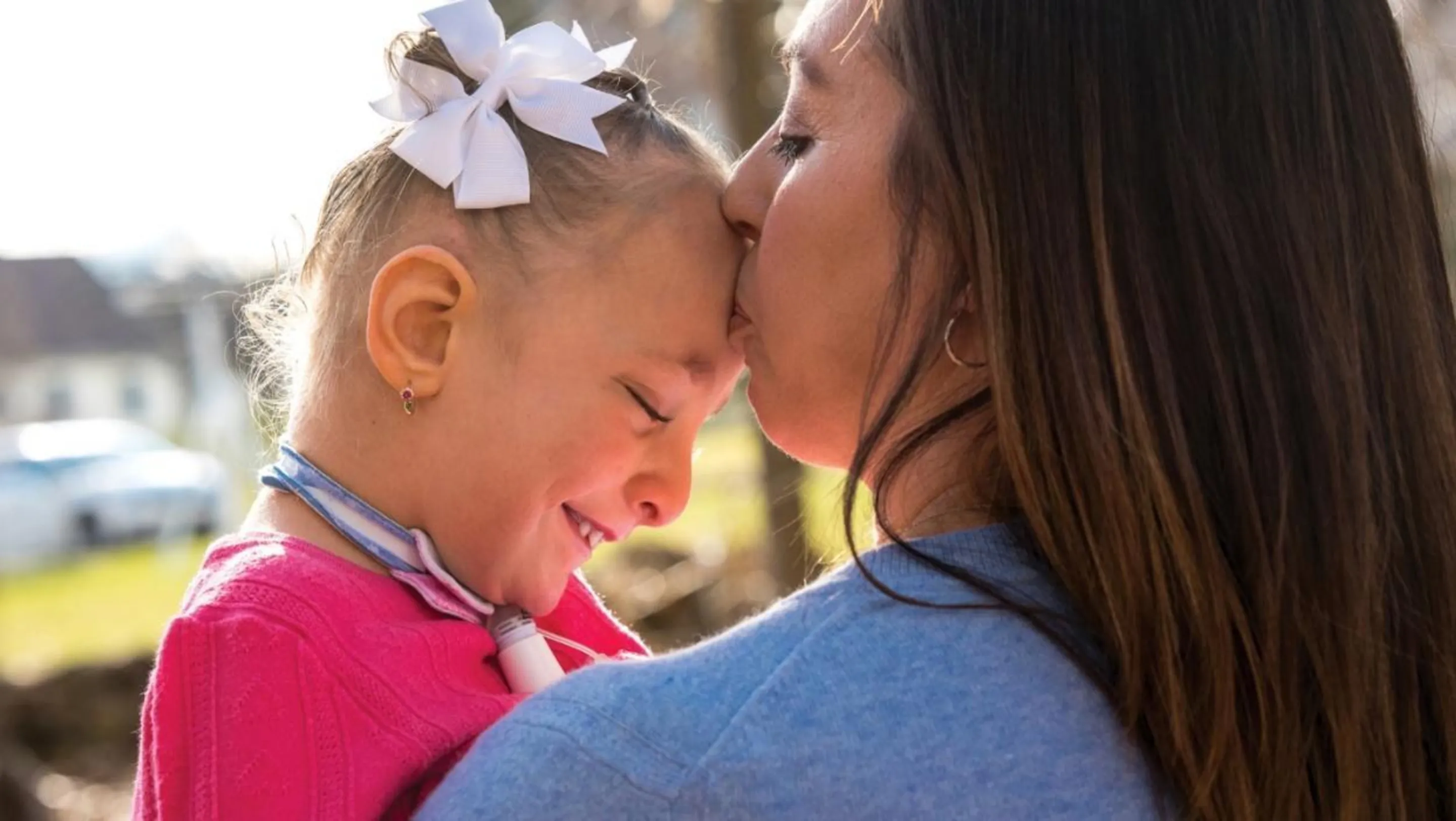 A woman kisses her daughter, Kennedy