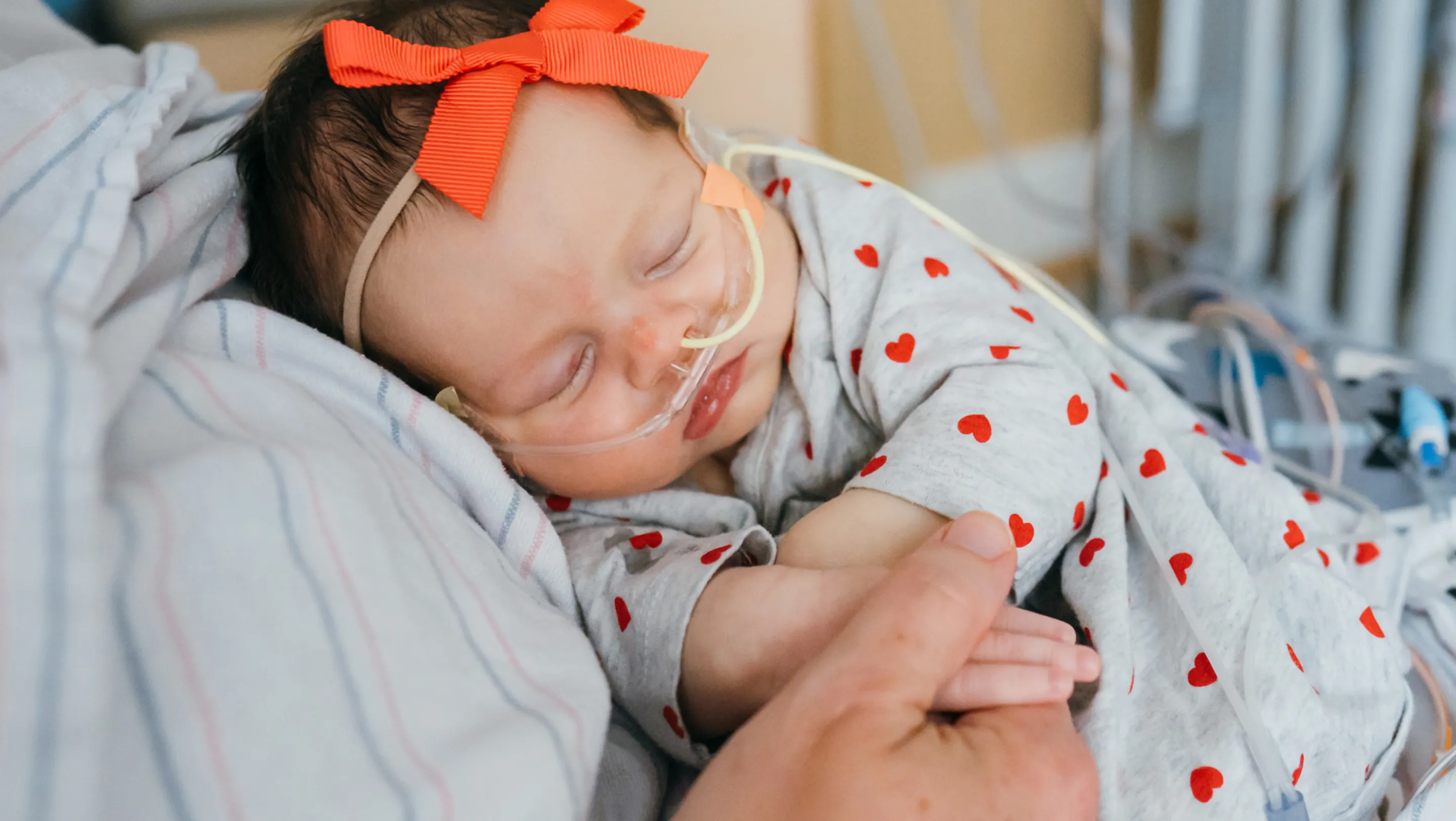 Kalea with a breathing tube being held by her mother