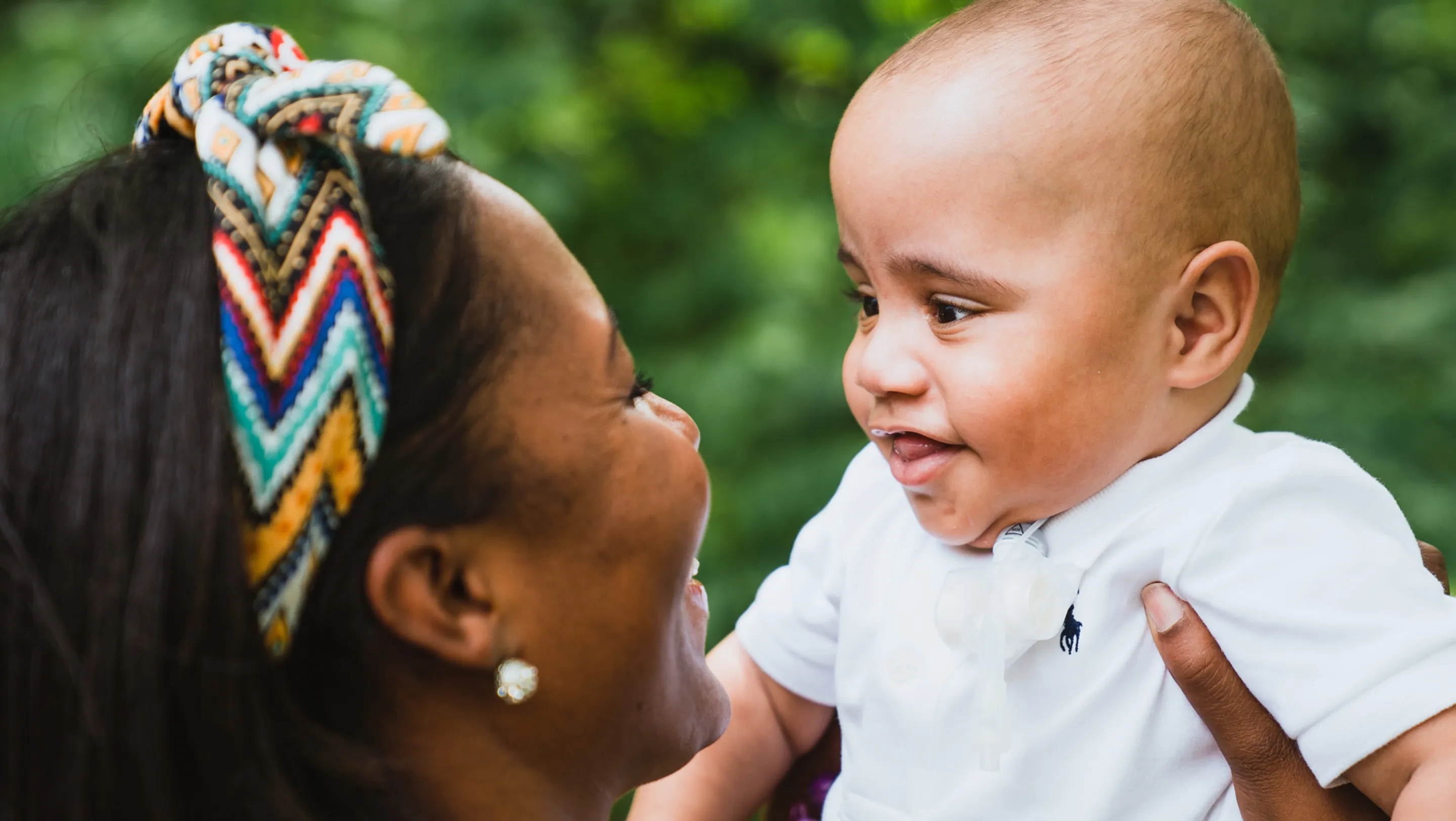 kole smiling and being held up by his mother