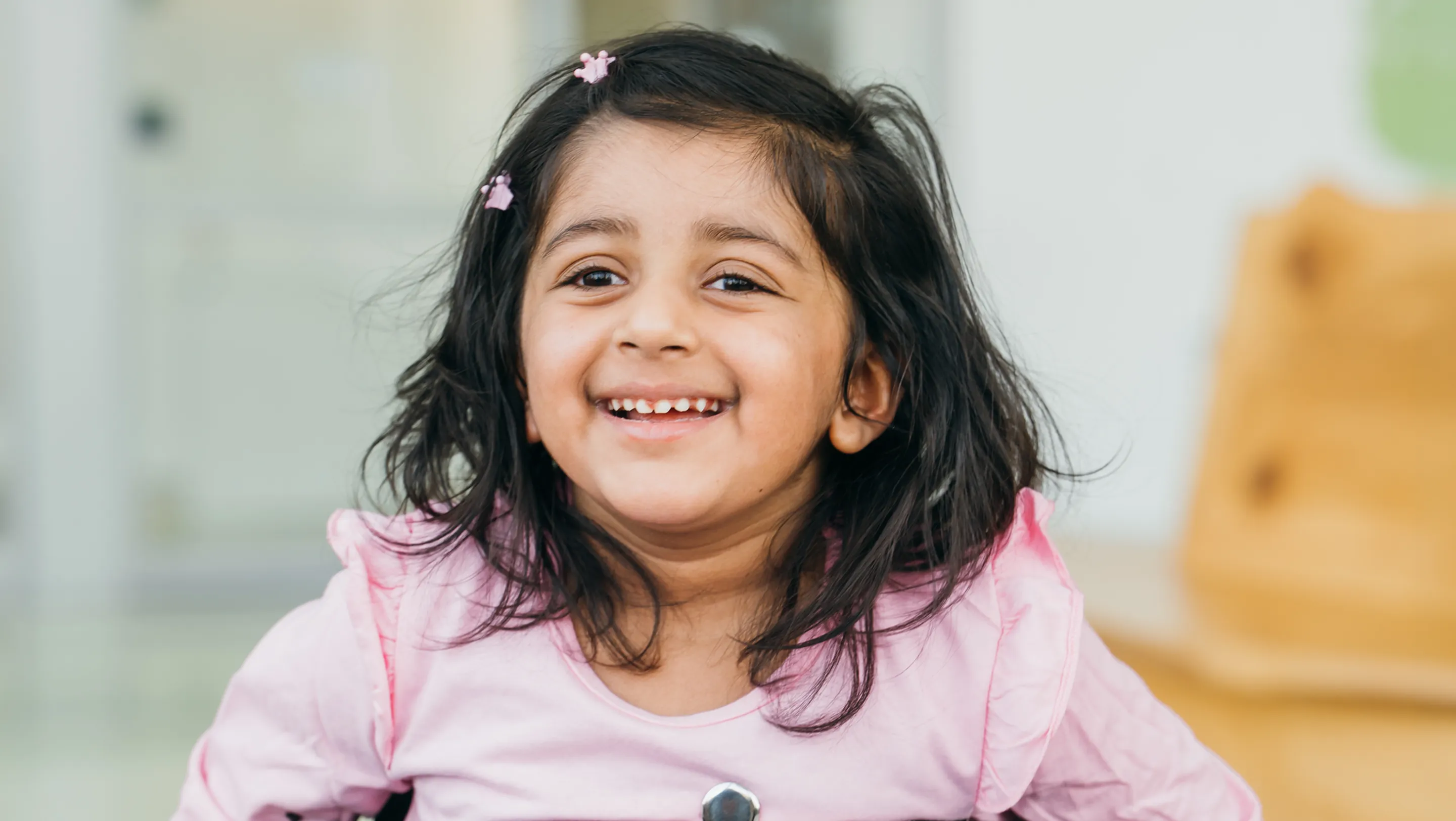 image of a toddler on a wheelchair smiling 