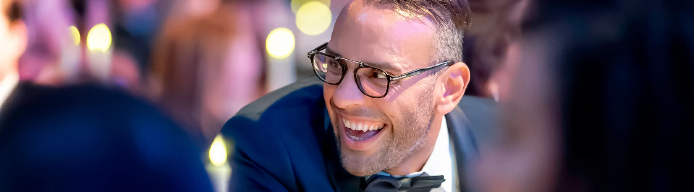 A man wearing a tuxedo smiles at the Milagros para Ninos Event for BCH