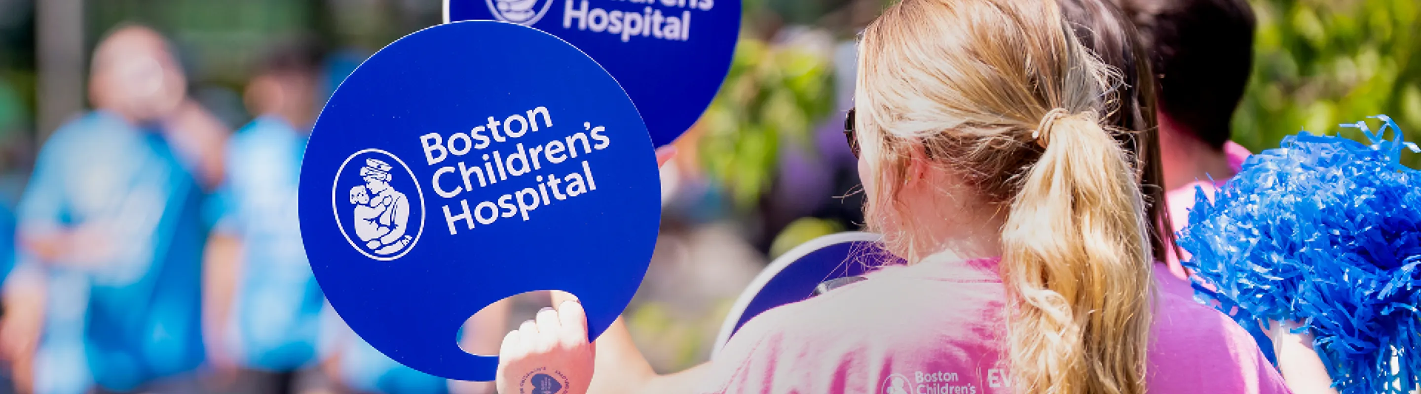 People wave signs at event for Boston Childrens Hospital