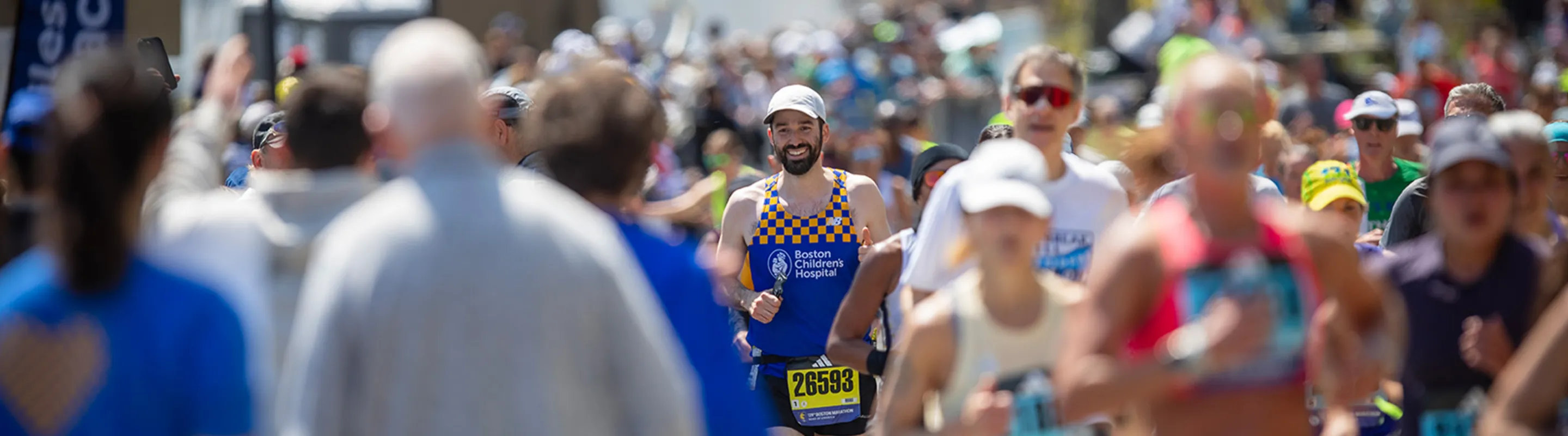 view of marathon runners and spectators on a sunny day