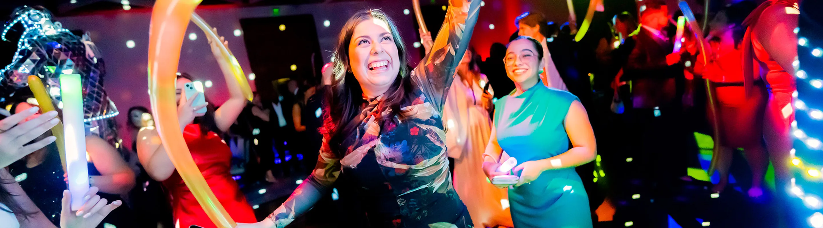 women smiling holding stretchy balloons at a gala