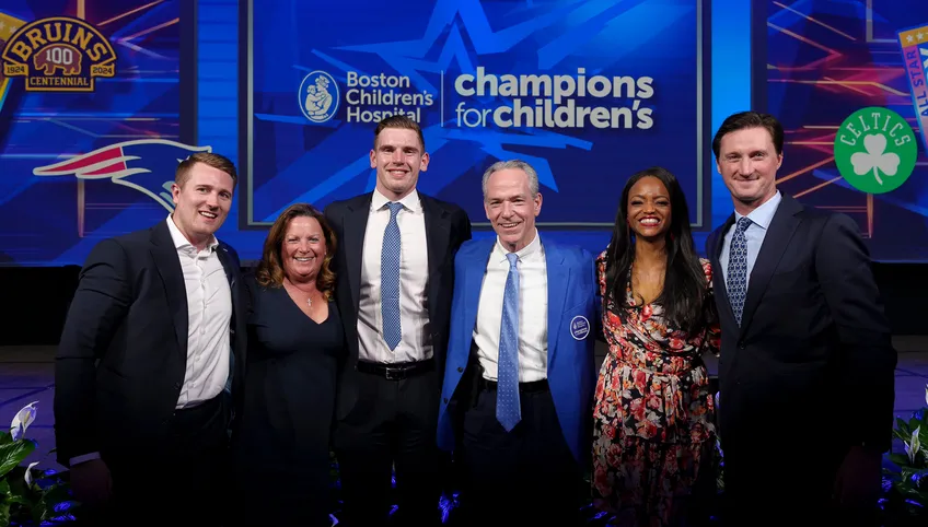 Champions for Childrens event speakers and guests pose in front of an event banner