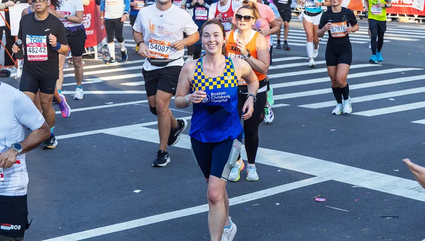 Woman running marathon smiling.