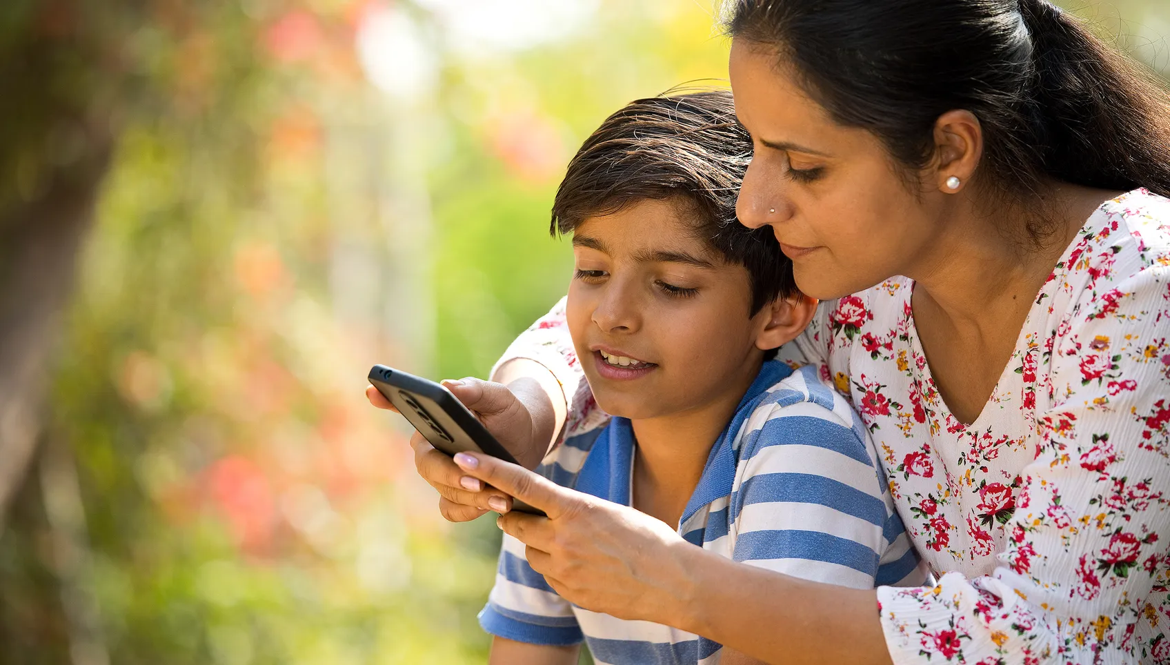 Mom and young son looking at a mobile device