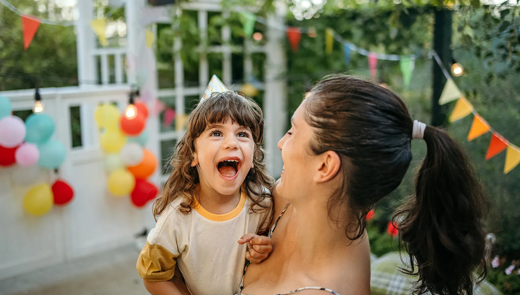 woman holding young girl at her birthday party