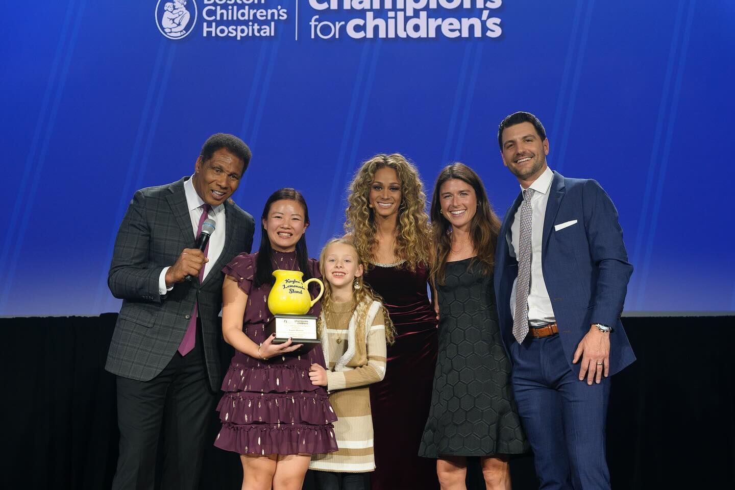 group of people standing on Champions for Children's stage