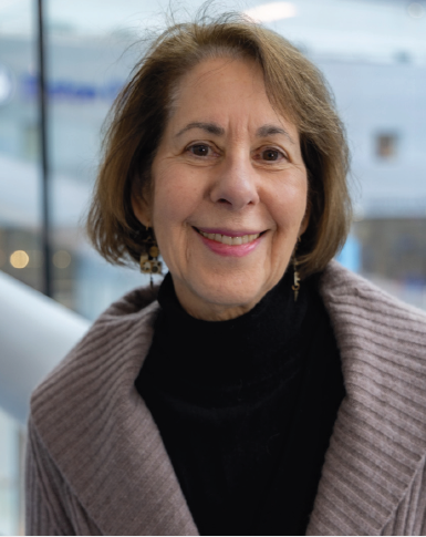 woman smiling wearing black turtleneck underneath sweater