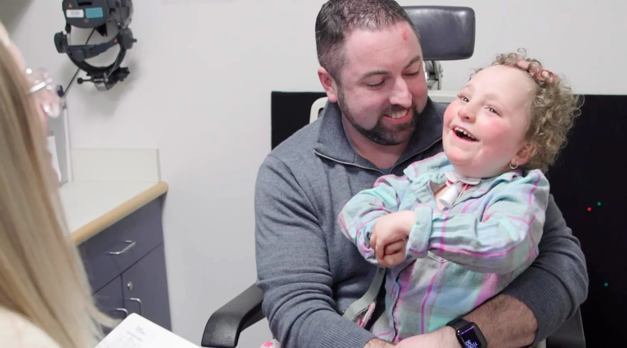 A BCH patient, Kennedy, laughs in her father's arms