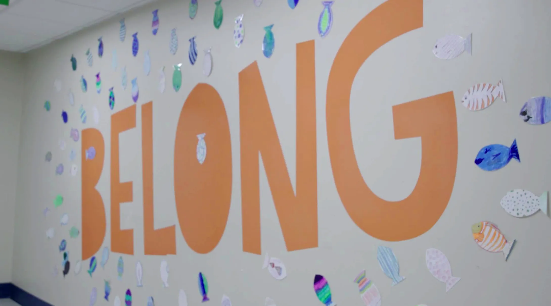 A wall covered with construction paper fish and large letters that read "Belong"