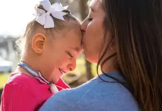 A woman kisses her daughter, Kennedy