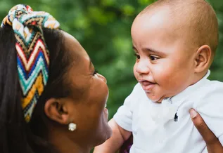 kole smiling and being held up by his mother