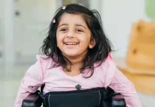 image of a toddler on a wheelchair smiling 